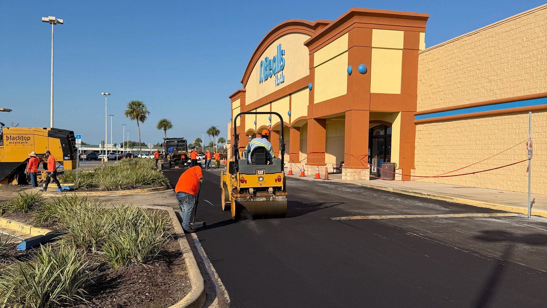 CAT roller and Blacktop Florida crew finishing the asphalt overlay at a retail parking lot in Lecanto, FL